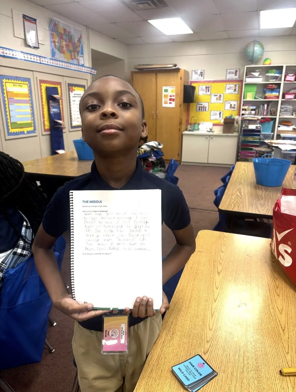A young author proudly holding up his handwritten story draft